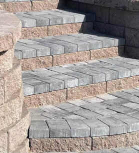 Durable retaining wall installation along a sloped backyard for soil support and erosion control